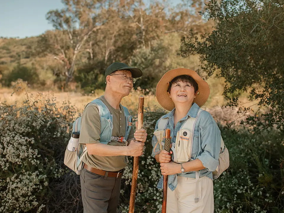 A grandmother and grandchild picking fruit in a garden