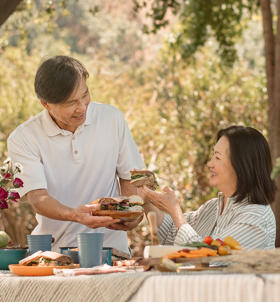 An older couple smiling while looking at a phone together